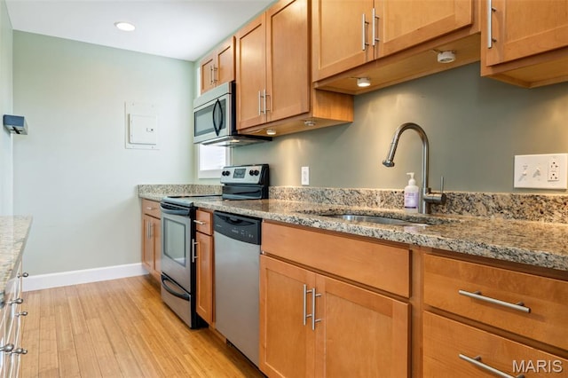 4220 Mcpherson Ave Unit 303, Saint Louis, MO 63108 - kitchen featuring stainless steel appliances, light wood-type flooring, light stone counters, recessed lighting, and brown cabinets