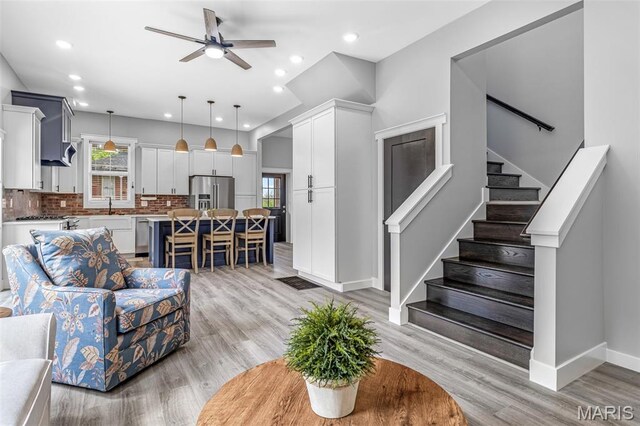 422 N 2nd St, De Soto, MO 63020 - living room featuring a ceiling fan, light wood finished floors, stairs, and recessed lighting