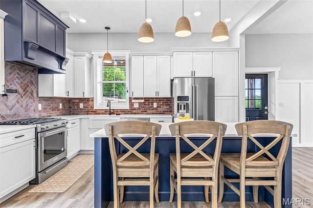 422 N 2nd St, De Soto, MO 63020 - kitchen with appliances with stainless steel finishes, decorative backsplash, light wood finished floors, light countertops, and a breakfast bar area