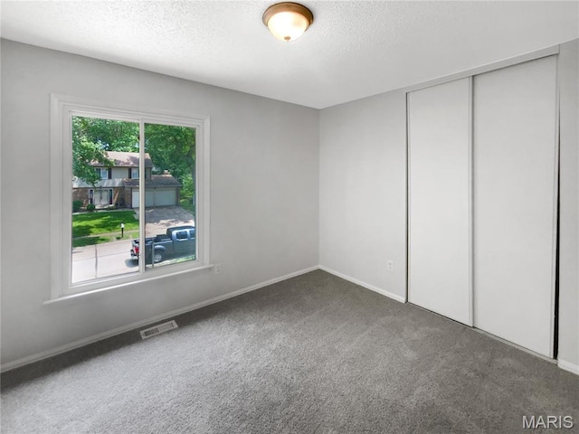 887 Totem Woods Ct, Manchester, MO 63021 - unfurnished bedroom with a textured ceiling, carpet, and a closet