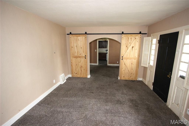 205 Deguire, Fredericktown, MO 63645 - spare room with a barn door, arched walkways, and dark colored carpet
