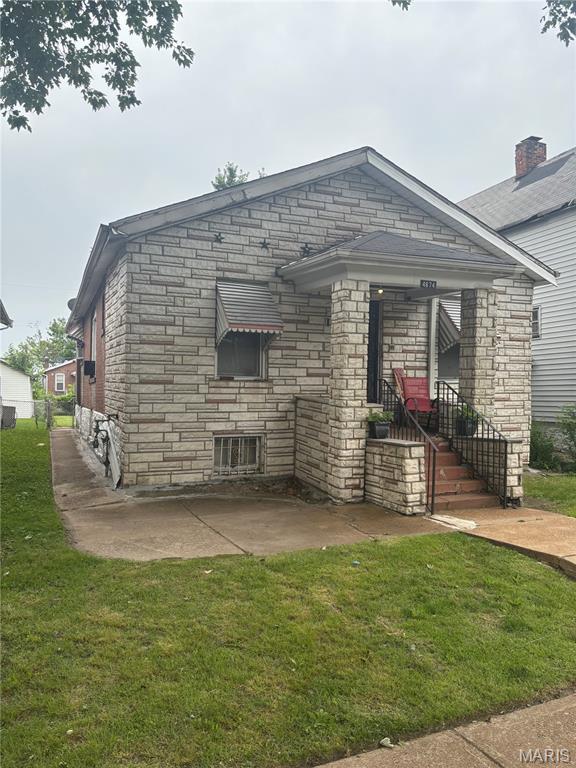 4874 Margaretta Ave, Saint Louis, MO 63115 - view of front facade with a front yard, stone siding, and a patio