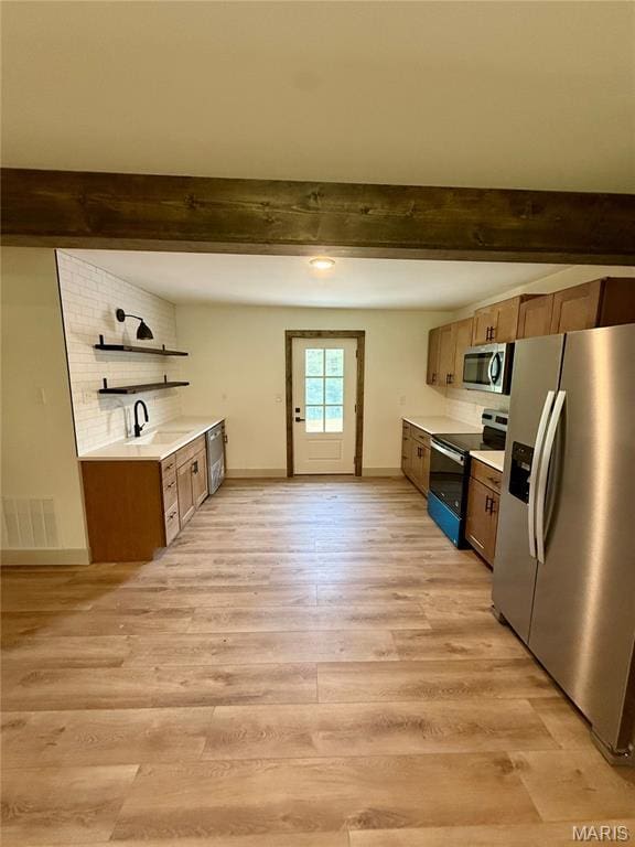 10293 Strange Rd, Potosi, MO 63664 - kitchen with appliances with stainless steel finishes, beam ceiling, light countertops, light wood-style floors, and open shelves