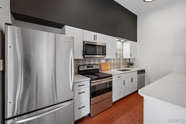 1302 S 10th, Saint Louis, MO 63104 - kitchen featuring stainless steel appliances, decorative backsplash, light countertops, and white cabinetry
