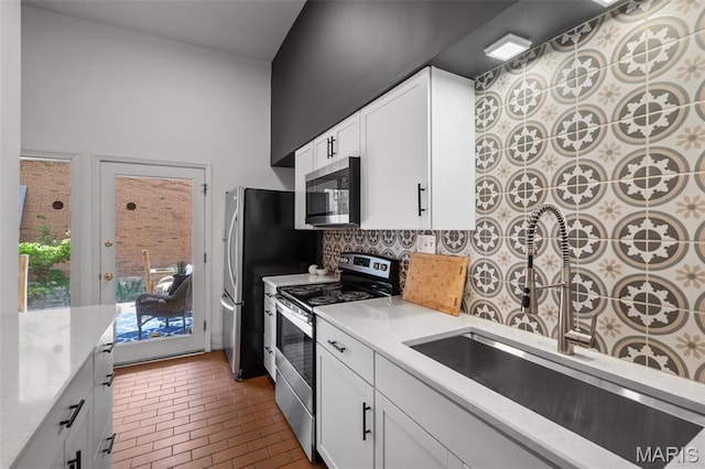 1302 S 10th, Saint Louis, MO 63104 - kitchen featuring stainless steel appliances, brick flooring, decorative backsplash, white cabinets, and light stone countertops