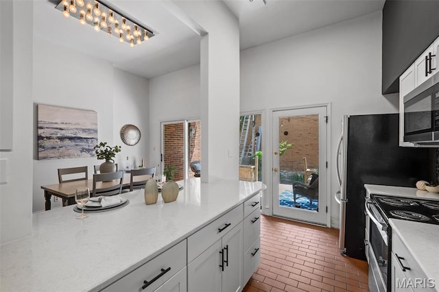 1302 S 10th, Saint Louis, MO 63104 - kitchen with appliances with stainless steel finishes, brick flooring, and white cabinets