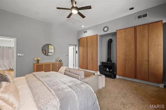 1302 S 10th, Saint Louis, MO 63104 - bedroom featuring a wood stove, ceiling fan, and light colored carpet