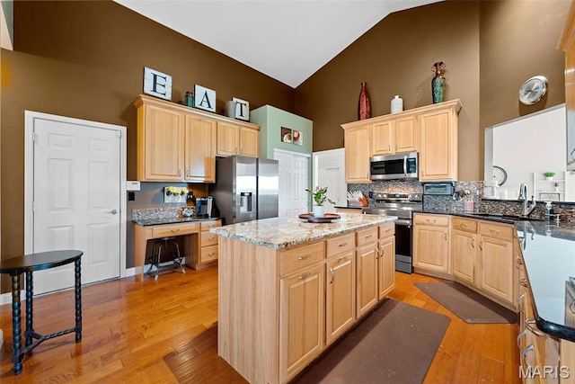 6 Wolverton Ct, Saint Charles, MO 63301 - kitchen with appliances with stainless steel finishes, light brown cabinetry, high vaulted ceiling, light wood finished floors, and decorative backsplash