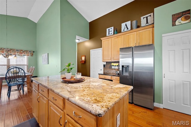 6 Wolverton Ct, Saint Charles, MO 63301 - kitchen featuring stainless steel fridge, high vaulted ceiling, a center island, light wood-type flooring, and light stone counters