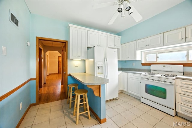 4934 Tiemann Ave, Saint Louis, MO 63123 - kitchen featuring white appliances, white cabinets, ceiling fan, a kitchen bar, and light tile patterned floors