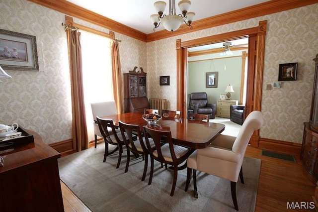302 N Main St, Saint Elmo, IL 62458 - dining area featuring wood-type flooring, wallpapered walls, radiator, and a chandelier