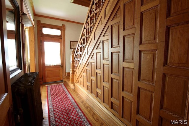 302 N Main St, Saint Elmo, IL 62458 - doorway to outside with radiator heating unit, wood finished floors, ornamental molding, and stairway