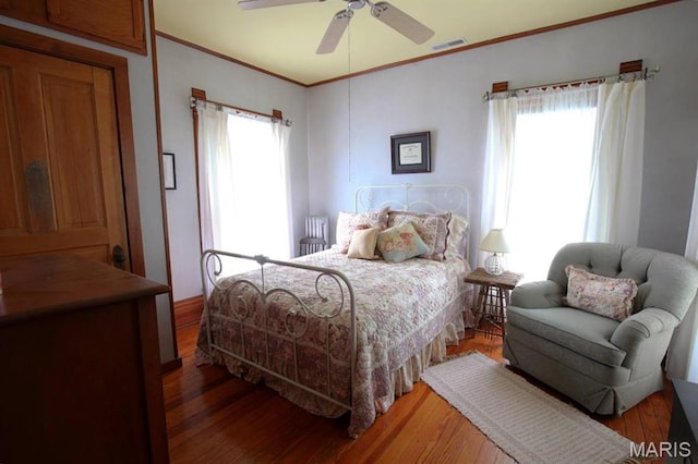 302 N Main St, Saint Elmo, IL 62458 - bedroom with ornamental molding, multiple windows, hardwood / wood-style floors, and a ceiling fan