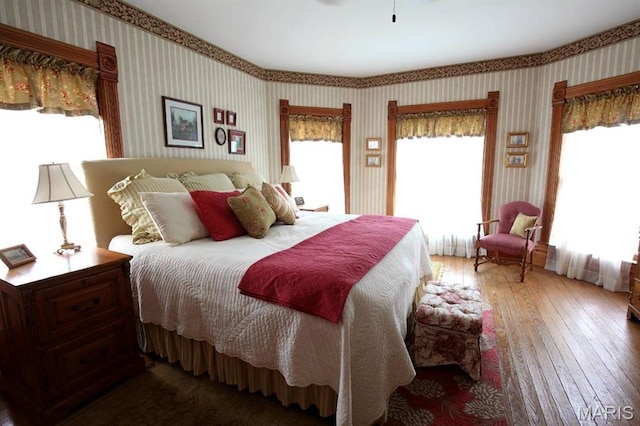 302 N Main St, Saint Elmo, IL 62458 - bedroom with wallpapered walls, multiple windows, and wood-type flooring