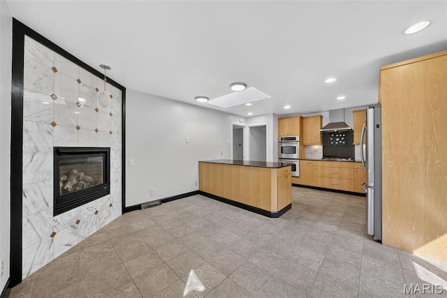 3 Cardigan Ln, Saint Louis, MO 63135 - kitchen with wall chimney exhaust hood, appliances with stainless steel finishes, dark countertops, light brown cabinetry, and recessed lighting