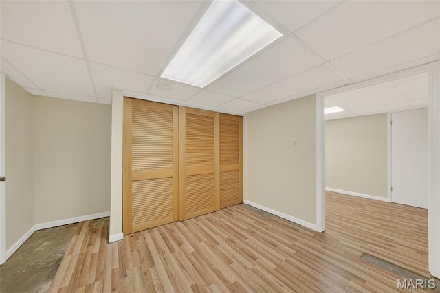3 Cardigan Ln, Saint Louis, MO 63135 - unfurnished bedroom with a drop ceiling, a closet, and wood finished floors