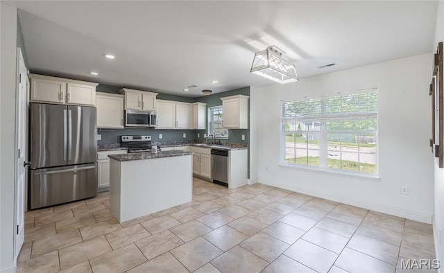 111 Brush Creek Pkwy, Saint Robert, MO 65584 - kitchen with appliances with stainless steel finishes, white cabinets, dark stone countertops, recessed lighting, and a center island