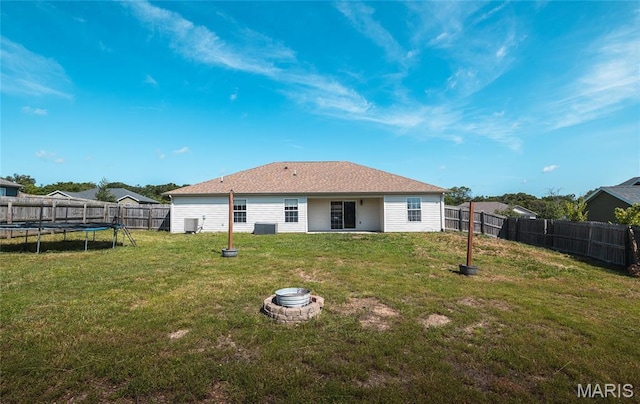 111 Brush Creek Pkwy, Saint Robert, MO 65584 - rear view of property featuring a trampoline, a fenced backyard, and a fire pit