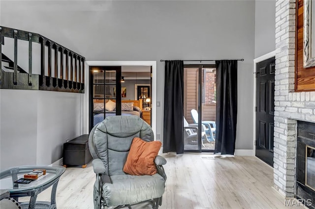 225 Hemingway Ln Unit F, Weldon Spring, MO 63304 - sitting room with wood finished floors, a brick fireplace, and a towering ceiling