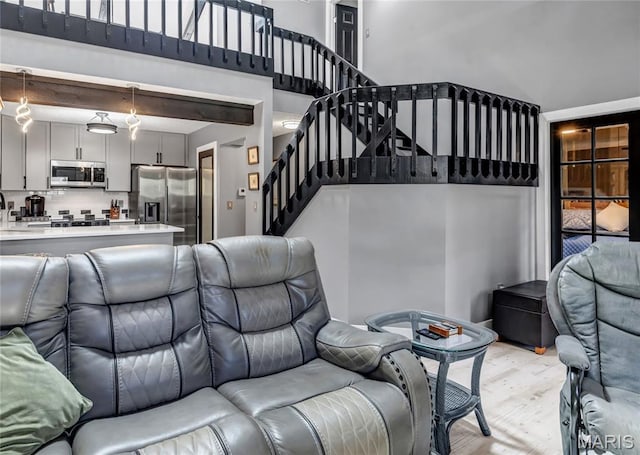 225 Hemingway Ln Unit F, Weldon Spring, MO 63304 - living area with light wood-style flooring, stairs, and a high ceiling