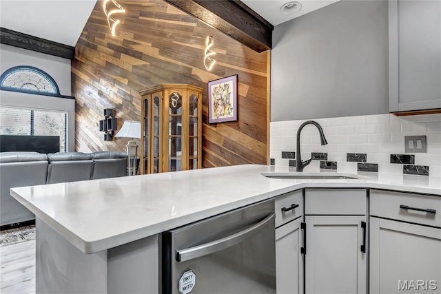 225 Hemingway Ln Unit F, Weldon Spring, MO 63304 - kitchen with stainless steel dishwasher, wood walls, a peninsula, backsplash, and light countertops