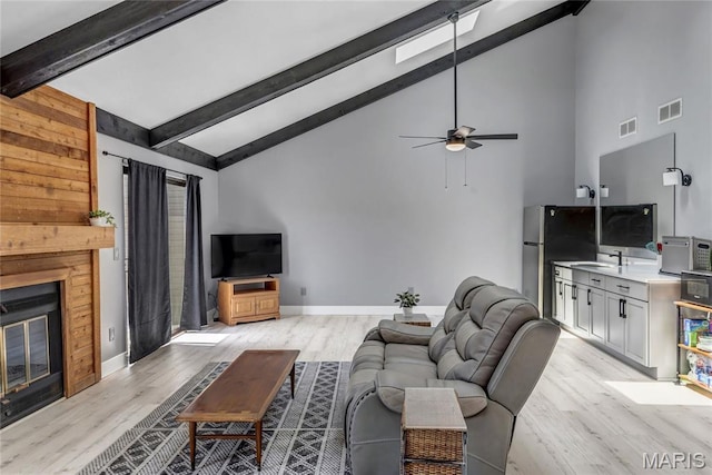 225 Hemingway Ln Unit F, Weldon Spring, MO 63304 - living area featuring light wood finished floors, beam ceiling, a glass covered fireplace, ceiling fan, and high vaulted ceiling