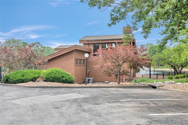 225 Hemingway Ln Unit F, Weldon Spring, MO 63304 - view of side of property featuring uncovered parking and a chimney