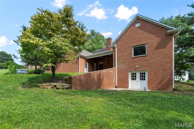 2615 Saddle Ridge Ln, Cape Girardeau, MO 63701 - rear view of house featuring a lawn, brick siding, and a chimney
