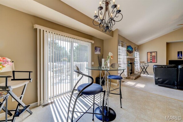 70 Boschert Creek Dr, Saint Peters, MO 63376 - dining area featuring vaulted ceiling, a chandelier, a fireplace with raised hearth, and tile patterned floors