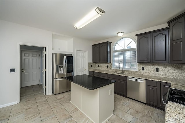 86 Homefield Square Ct, Ofallon, MO 63366 - kitchen featuring appliances with stainless steel finishes, tasteful backsplash, light stone counters, a kitchen island, and light tile patterned flooring