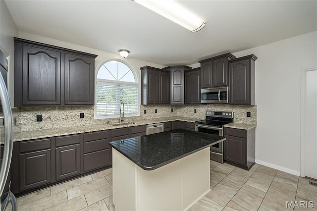 86 Homefield Square Ct, Ofallon, MO 63366 - kitchen featuring appliances with stainless steel finishes, backsplash, light stone countertops, a center island, and light tile patterned flooring