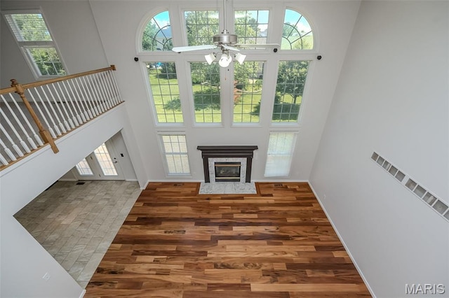 86 Homefield Square Ct, Ofallon, MO 63366 - unfurnished living room featuring a towering ceiling, wood finished floors, a premium fireplace, a ceiling fan, and stairs