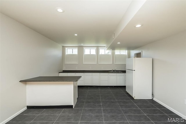 86 Homefield Square Ct, Ofallon, MO 63366 - kitchen featuring freestanding refrigerator, dark countertops, white cabinets, dark tile patterned flooring, and recessed lighting
