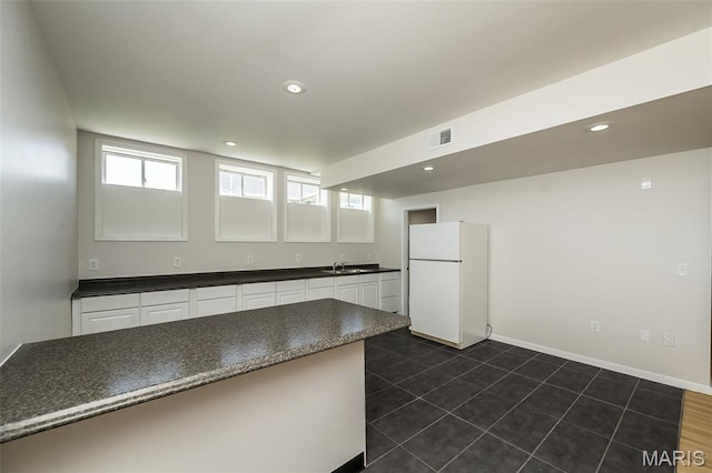 86 Homefield Square Ct, Ofallon, MO 63366 - kitchen featuring freestanding refrigerator, dark countertops, white cabinets, recessed lighting, and dark tile patterned floors