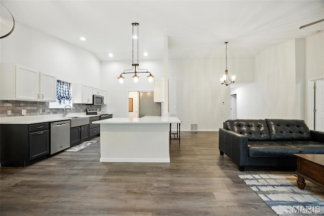 1575 Hickory Lndg, De Soto, MO 63020 - kitchen with stainless steel appliances, a towering ceiling, open floor plan, a chandelier, and light countertops