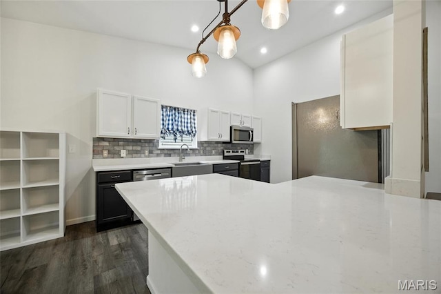 1575 Hickory Lndg, De Soto, MO 63020 - kitchen with appliances with stainless steel finishes, white cabinets, dark wood-type flooring, backsplash, and a peninsula