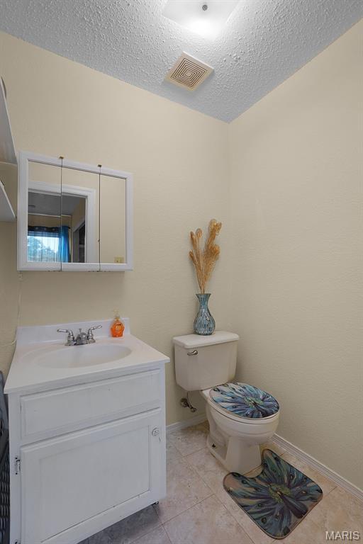 351 Orion Dr, De Soto, MO 63020 - half bathroom featuring vanity, a textured ceiling, and tile patterned floors