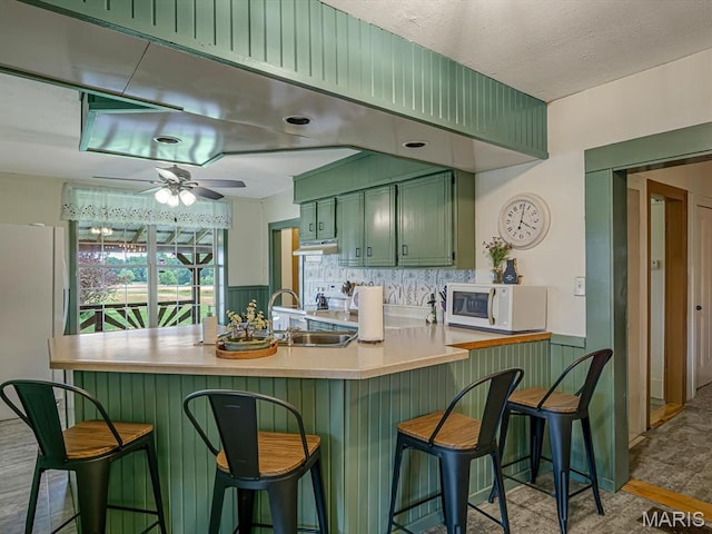 1767 Ames Rd, Prairie Du Rocher, IL 62277 - kitchen featuring green cabinetry, white appliances, under cabinet range hood, light countertops, and tasteful backsplash
