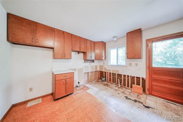 10820 Clayton Ct, Rolla, MO 65401 - kitchen featuring brown cabinets, light flooring, and tasteful backsplash