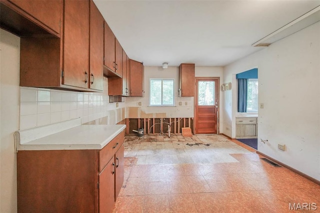 10820 Clayton Ct, Rolla, MO 65401 - kitchen featuring brown cabinets, light countertops, and backsplash