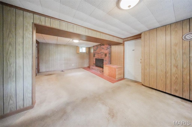10820 Clayton Ct, Rolla, MO 65401 - unfurnished living room featuring wood walls, a brick fireplace, and carpet flooring