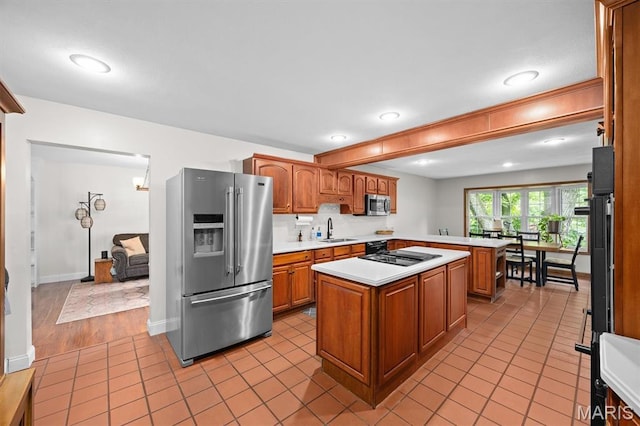 101 E Fairway Dr, Belleville, IL 62223 - kitchen featuring appliances with stainless steel finishes, light countertops, a kitchen island, brown cabinets, and recessed lighting