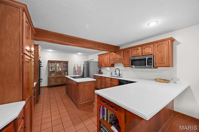 101 E Fairway Dr, Belleville, IL 62223 - kitchen with black appliances, light tile patterned flooring, brown cabinetry, a center island, and a peninsula