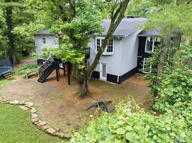 101 E Fairway Dr, Belleville, IL 62223 - back of house featuring a trampoline, a patio, a shingled roof, stairs, and a wooden deck