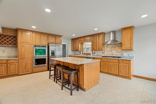 10 Rio Vista Dr, Frontier Township, MO 63303 - kitchen with wall chimney range hood, stainless steel appliances, recessed lighting, a breakfast bar, and light stone counters