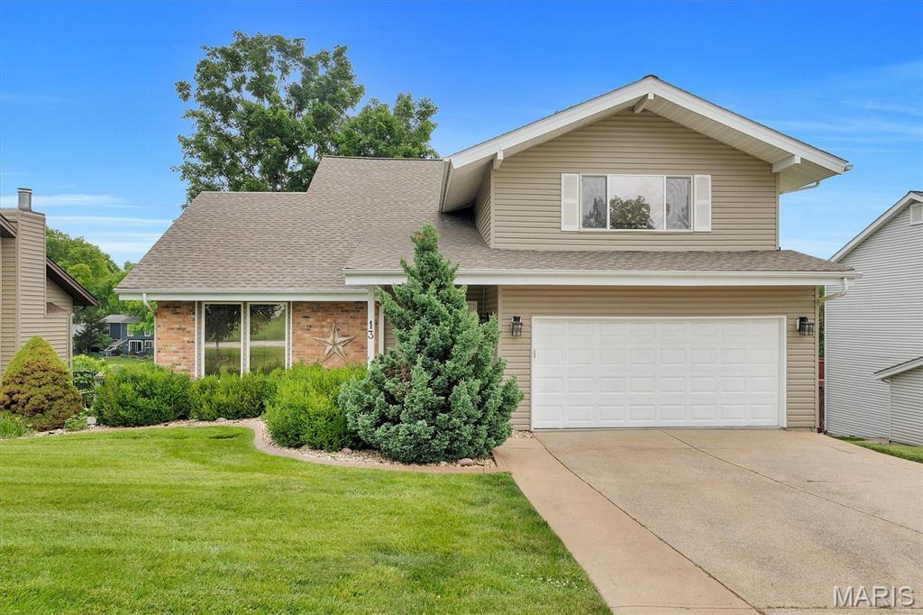13 Harbor Point Ct, Lake St Louis, MO 63367 - traditional-style house featuring a garage, a front yard, driveway, roof with shingles, and brick siding