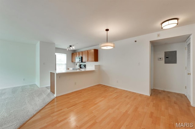 1125 Arbor Creek Dr Unit 2D, Saint Louis, MO 63122 - kitchen with electric panel, stainless steel microwave, light wood-style flooring, and light countertops
