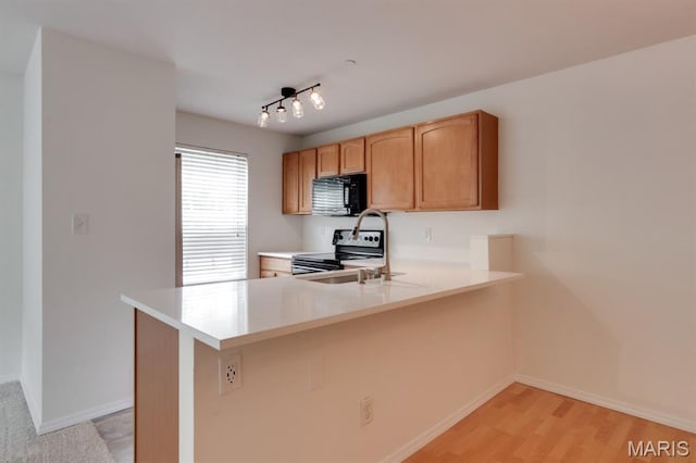 1125 Arbor Creek Dr Unit 2D, Saint Louis, MO 63122 - kitchen featuring stainless steel range with electric cooktop, black microwave, light countertops, a peninsula, and light wood-type flooring