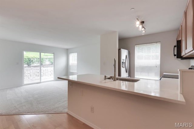 1125 Arbor Creek Dr Unit 2D, Saint Louis, MO 63122 - kitchen with stainless steel fridge with ice dispenser, a peninsula, light countertops, black microwave, and open floor plan