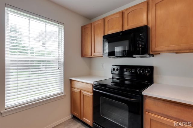 1125 Arbor Creek Dr Unit 2D, Saint Louis, MO 63122 - kitchen featuring black appliances, plenty of natural light, and light countertops